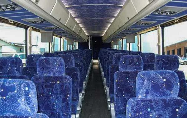 55 Passenger Charter Bus, the inside featuring overhead parcel racks