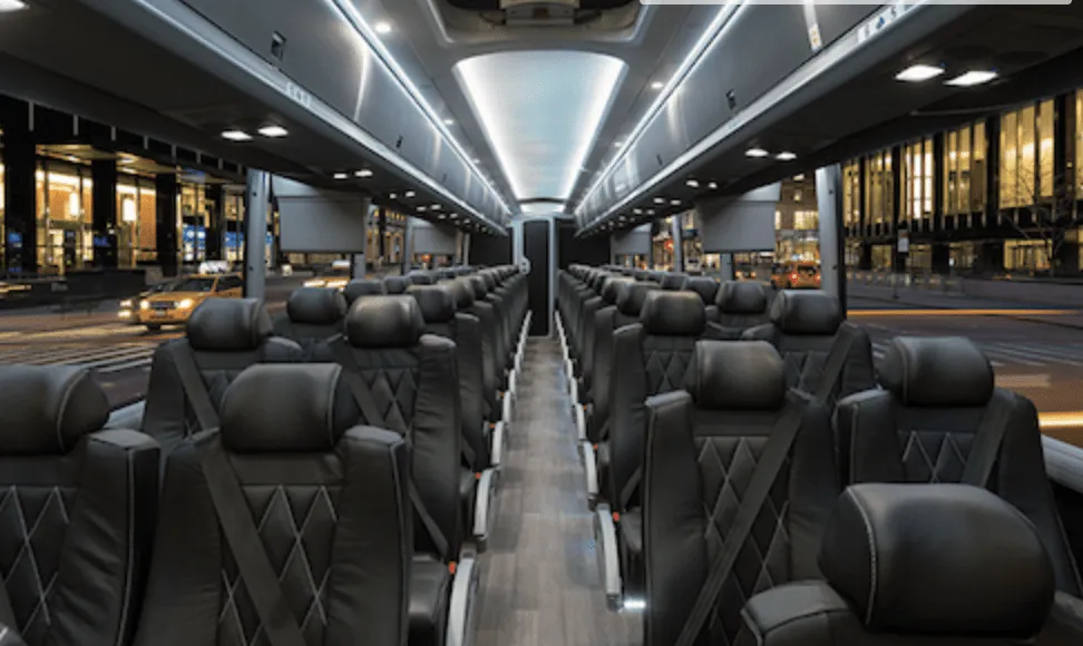 56 Passenger Charter Bus interior with LED ceiling lighting, passenger seat belts and overhead parcel racks for charter bus rental