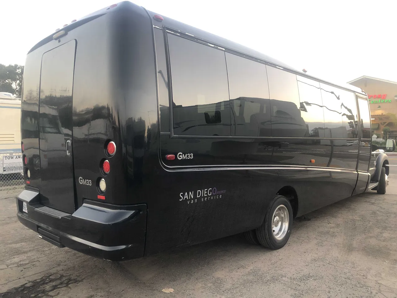 21 Passenger Mini Coach (black), outside view featuring tinted windows