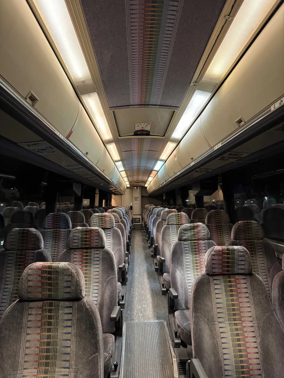 52 Passenger Motor Coach interior with overhead parcel racks for charter bus rental