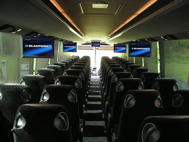 40 Passenger Motorcoach interior with LED ceiling lighting and TV screens for charter bus rental