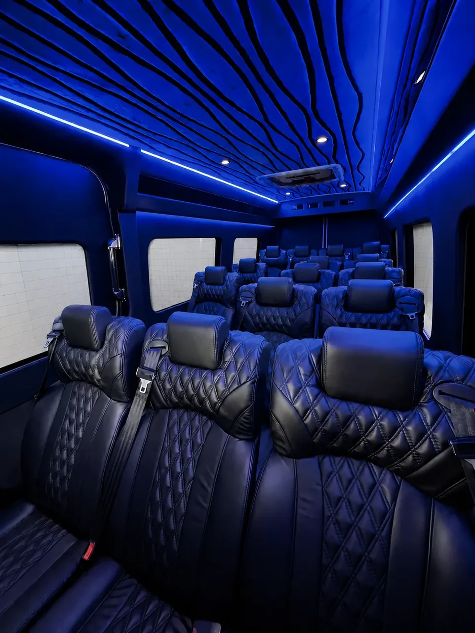 White Luxury Sprinter Shuttle Van, the inside featuring window shades, LED accent lighting and LED ceiling lighting